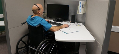 Man in wheelchair working at a desk