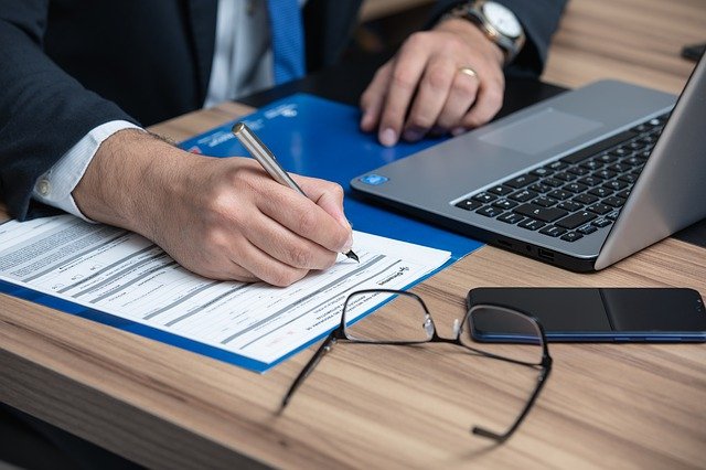 Closeup of a businessman writing on documents