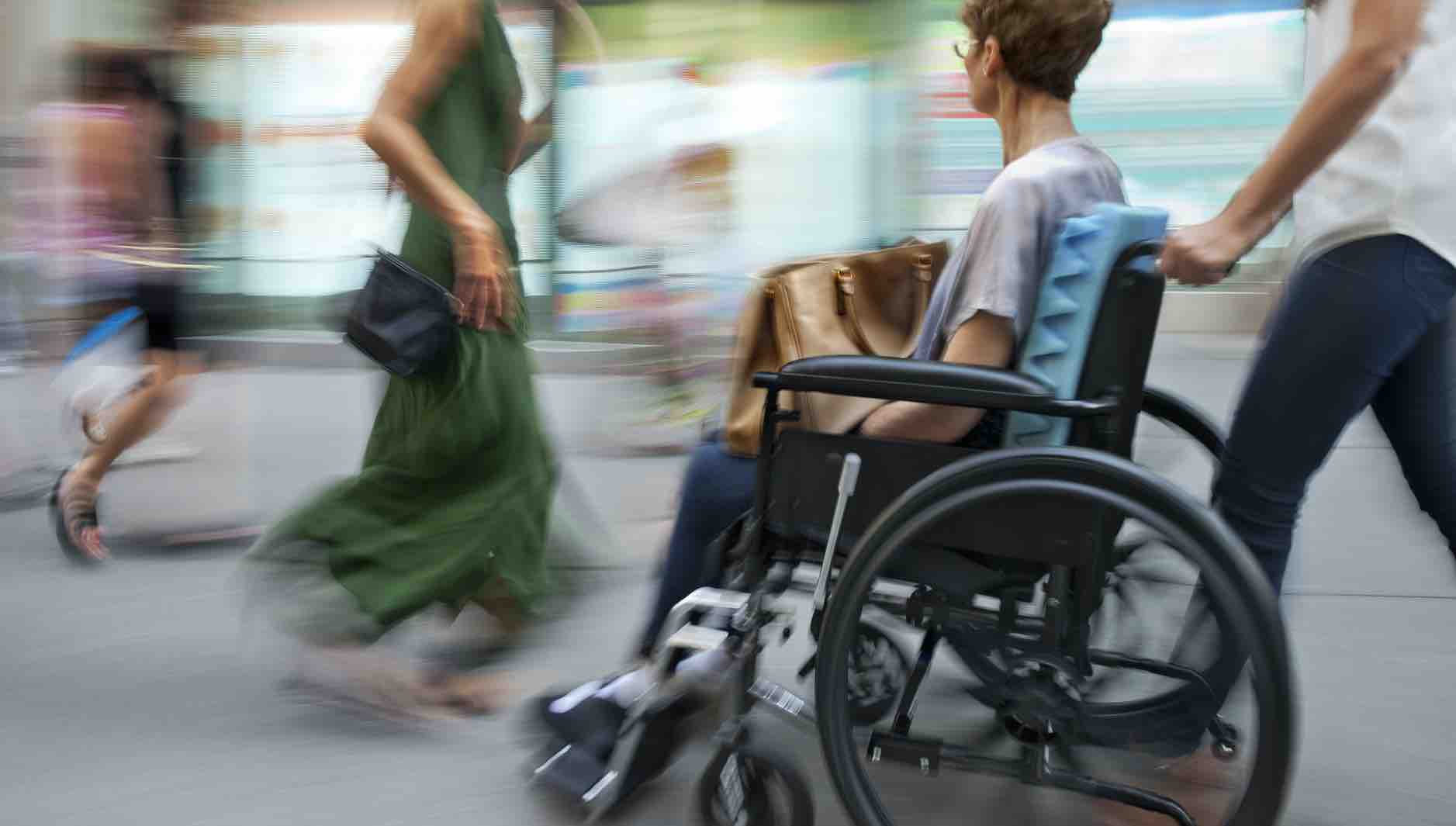 blurred movement a woman sitting in a wheelchair on a city street