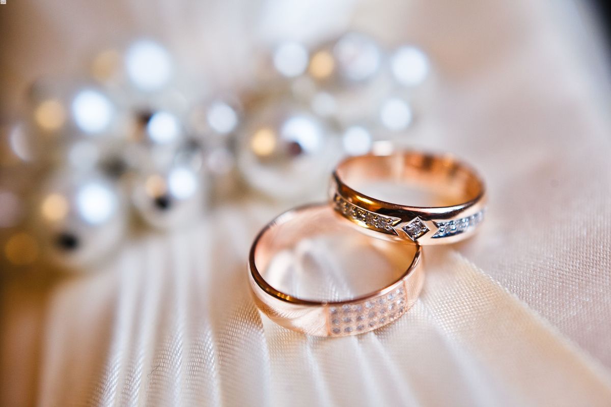 Two marriage rings placed on a wedding dress